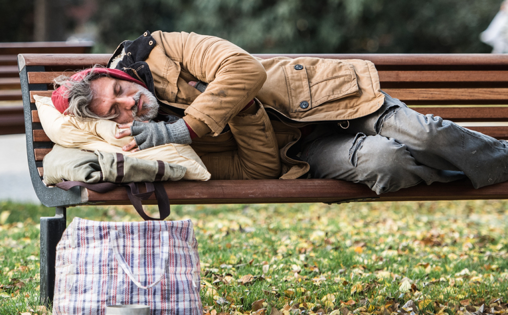 Un itinérant qui dort sur un banc