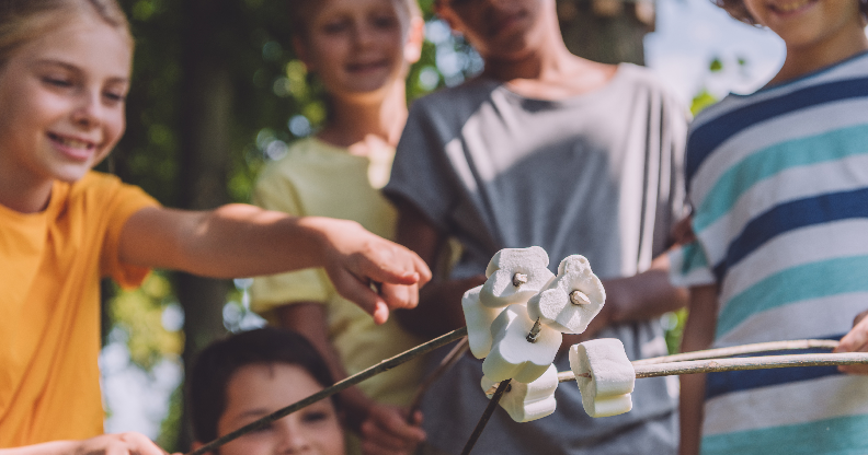 Jeunes enfants qui font griller des chamallows