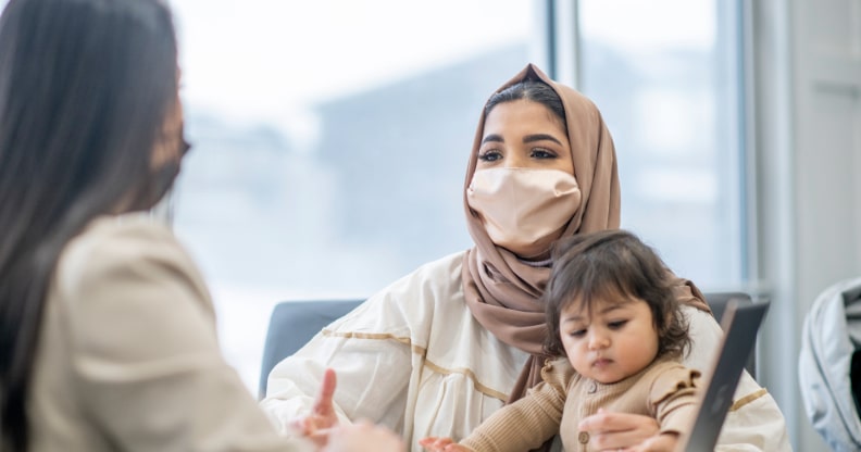 Femme voilée tenant un enfant dans ses bras
